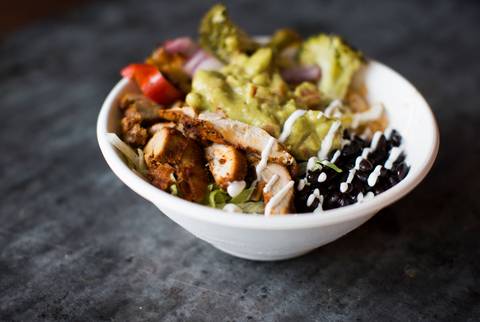 A bowl with chicken, guacamole, and black beans